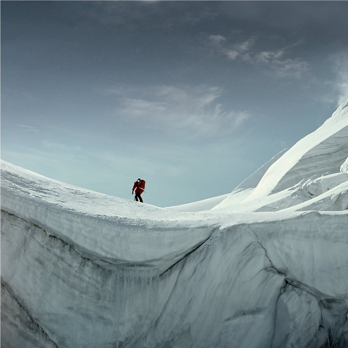 Hiker on snow-covered mountain ridge